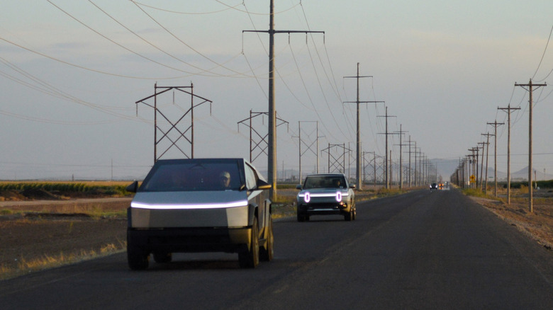 A Tesla and Rivian truck together on a highway.