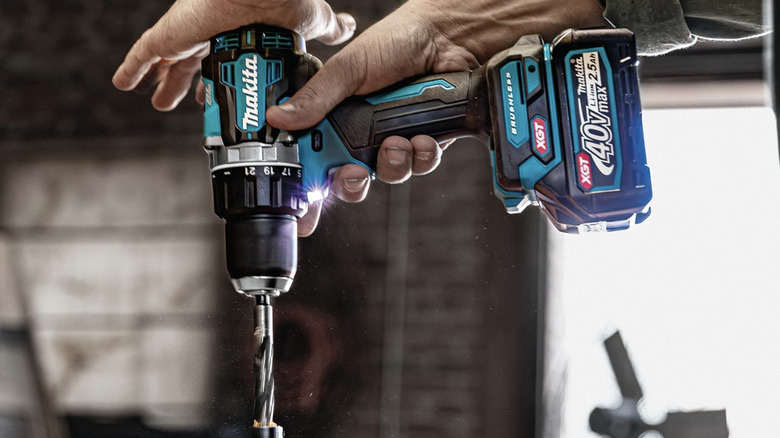 Close-up of a man's hands using a Makita cordless drill driver