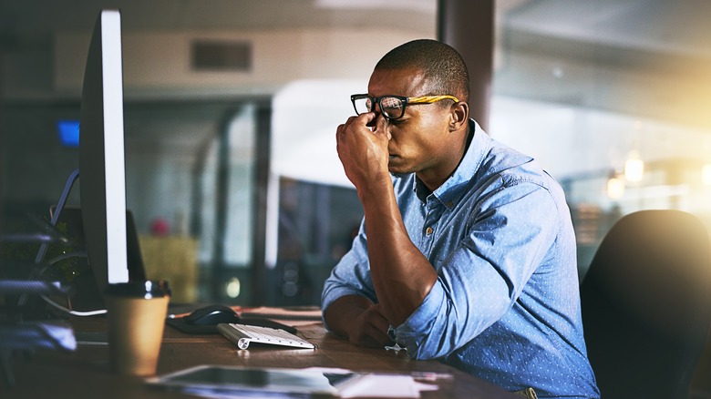 person stressed holding face desk