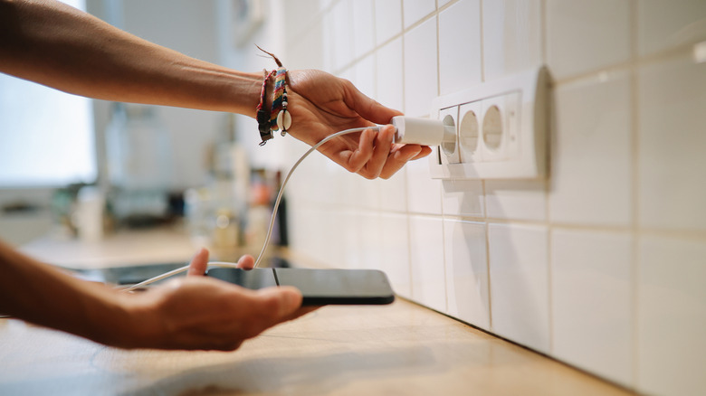 Person plugging in a phone charger