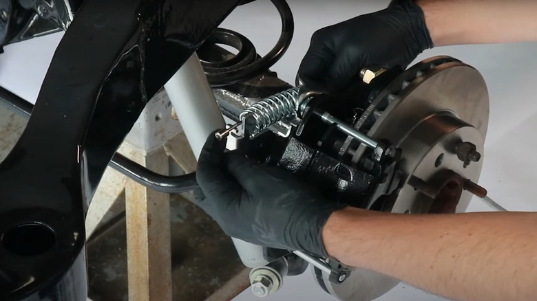 Mechanic installs a parking brake cable