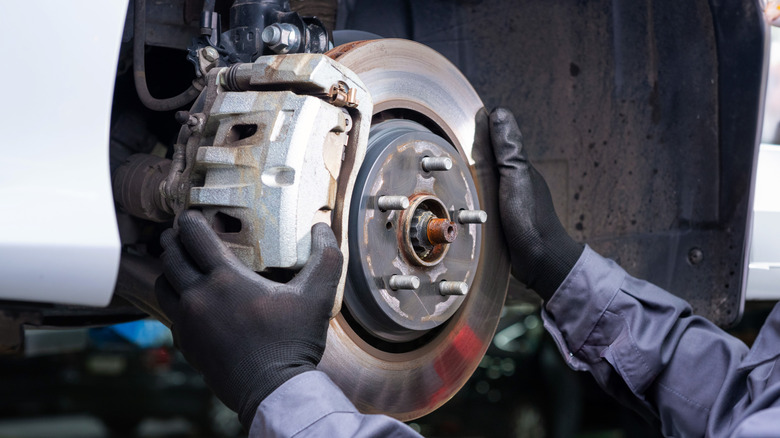 Mechanic replacing a caliper and brake pads