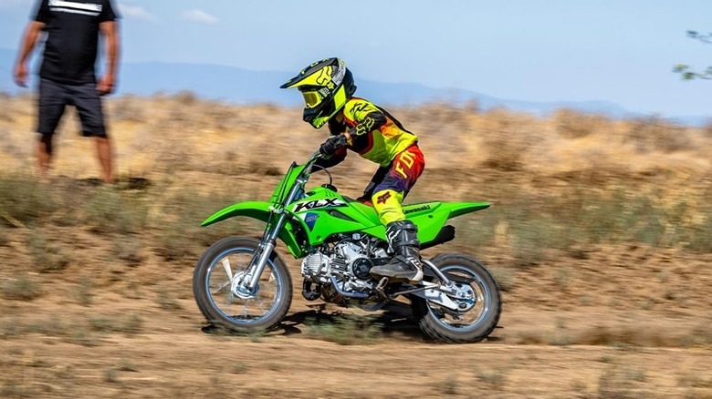 Rider riding a Kawasaki KLX110 on a dirt road