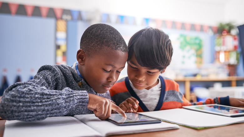 Young children using a tablet in class.