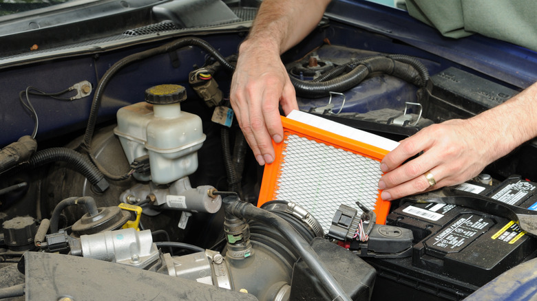 Man replacing car air filter 
