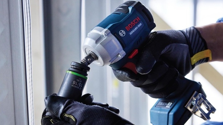 Hand holding Bosch impact wrench.