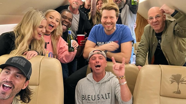 Kenny Chesney (center, seated) and friends aboard his Dassault Falcon 900EX in March 2023.