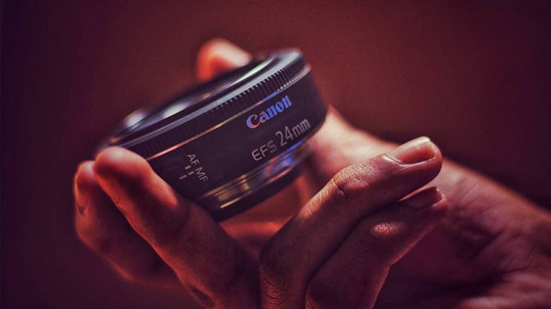 Person holding a Canon 24mm prime lens
