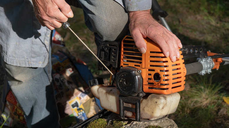 Someone performing maintenance on a chainsaw.