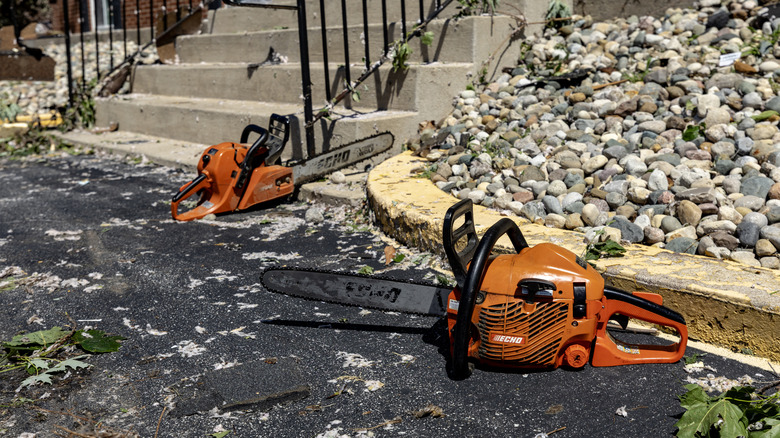 Two worn Echo saws on the ground.