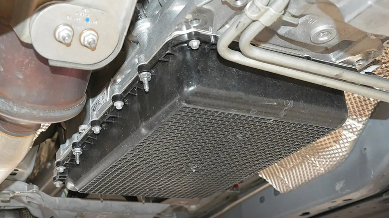 An under the hood of a car witha  section of a plastic transmission panner