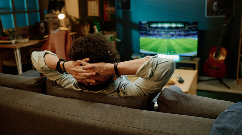 A person watching sports on a TV