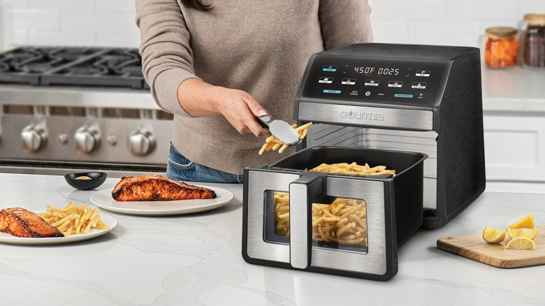 Woman cooks French fries in Gourmia air fryer