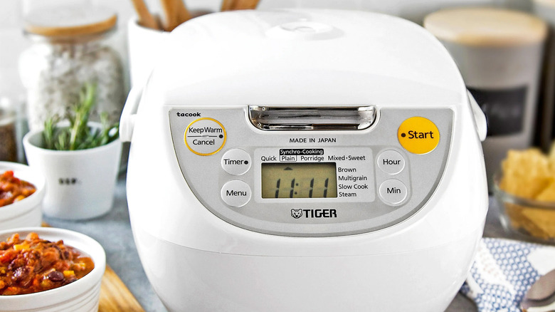 Tiger Rice cooker on counter alongside bowls of food
