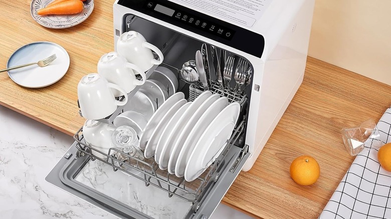Two dirty baby bottles sitting near a scrub brush