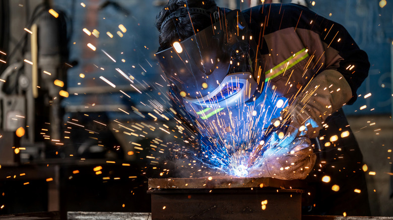 Person welding with sparks flying