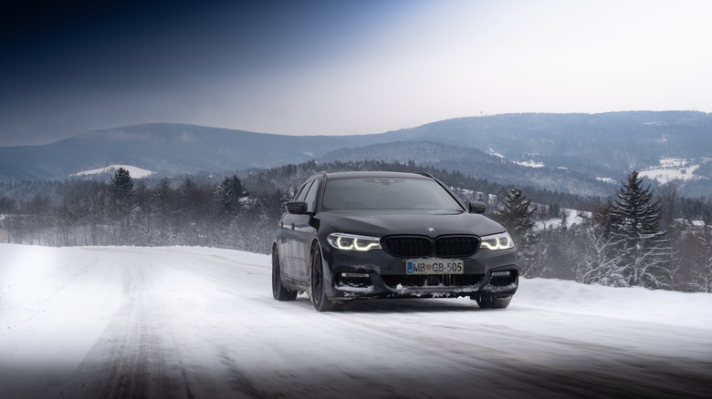 A luxury sedan on a snowy mountain road