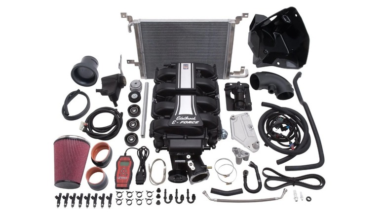 A supercharger kit for a 2011 Ford Mustang GT against a white background