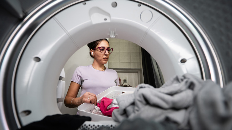 woman putting clothes in dryer