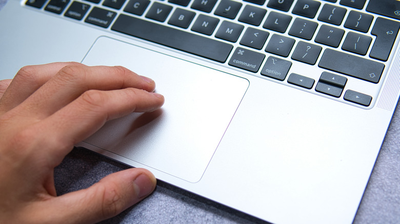 person using MacBook trackpad