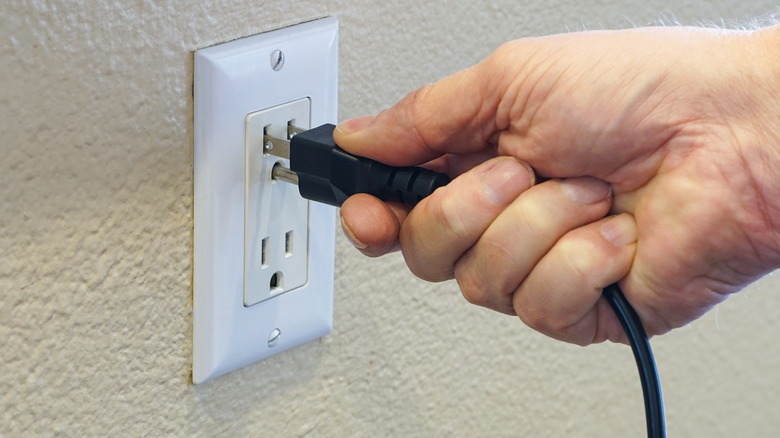 Person unplugging power cord