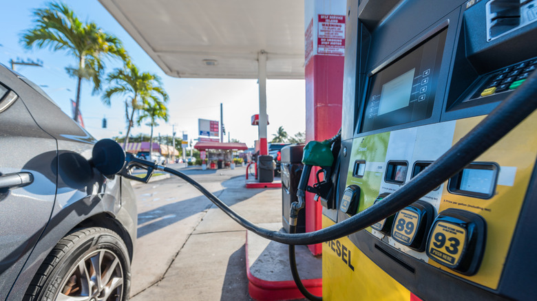 Car refueling at a gas station on a sunny morning.