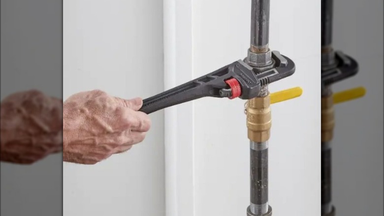 Using the Husky pipe wrench from Home Depot to tighten a pipe coupling.