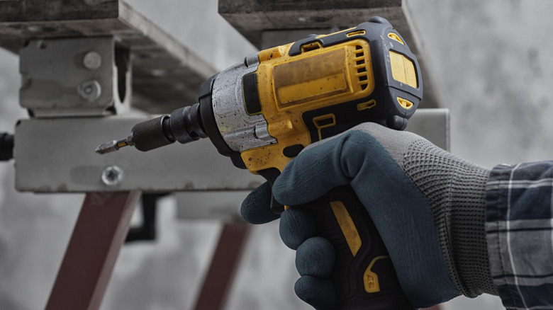 Person holding an impact driver with bit attached
