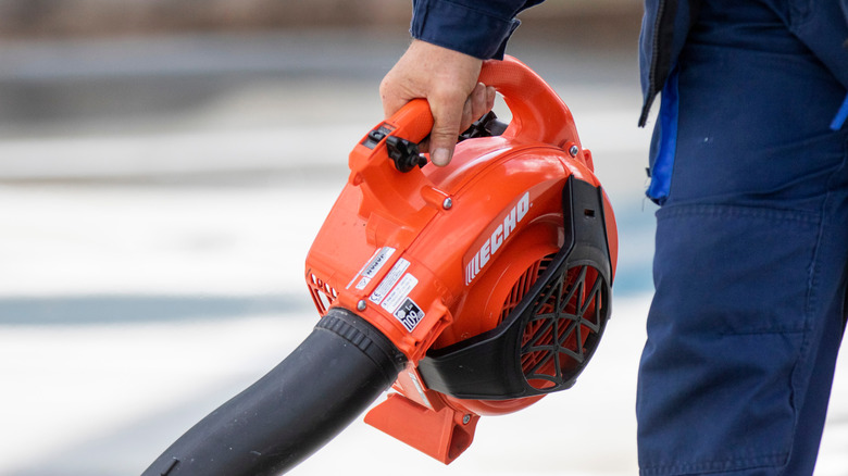 A man holding an ECHO brand leaf blower