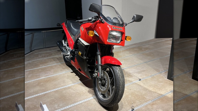 A red and black 1985 Kawasaki GPZ900R parked in a showroom