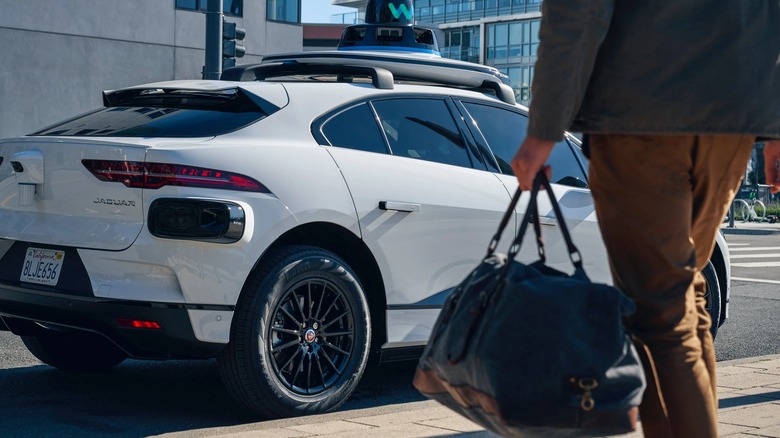 Passenger holding a bag with Waymo in front