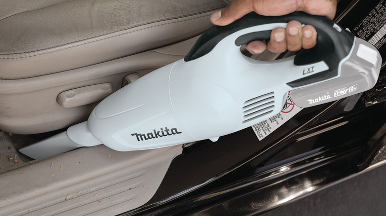 person using makita vacuum