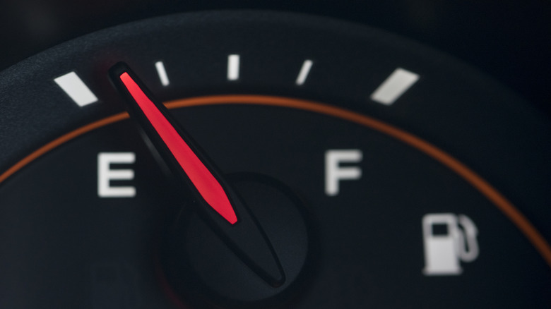 Car fuel gauge with the needle pointing at near empty