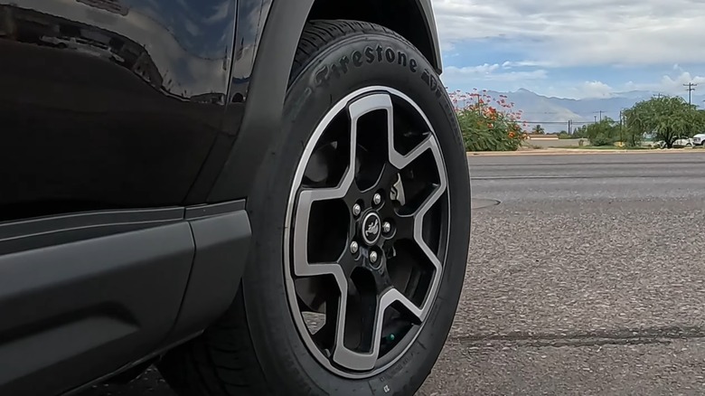 Close-up of a Firestone tire on a black car