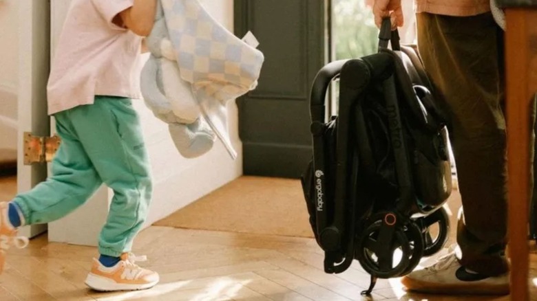 man holding folded ErgoBaby Metro 3 lightweight stroller