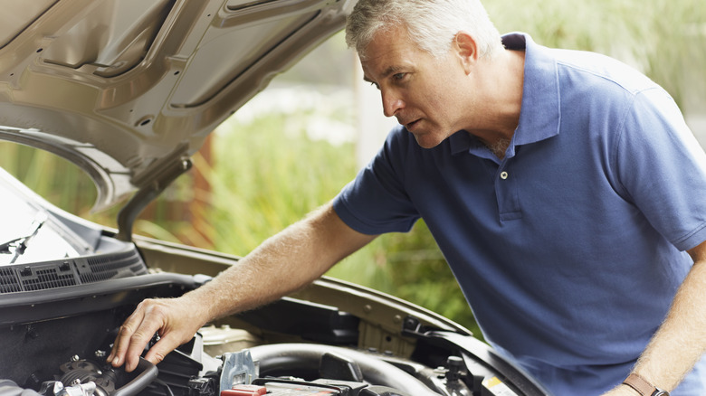 Man checking car engine