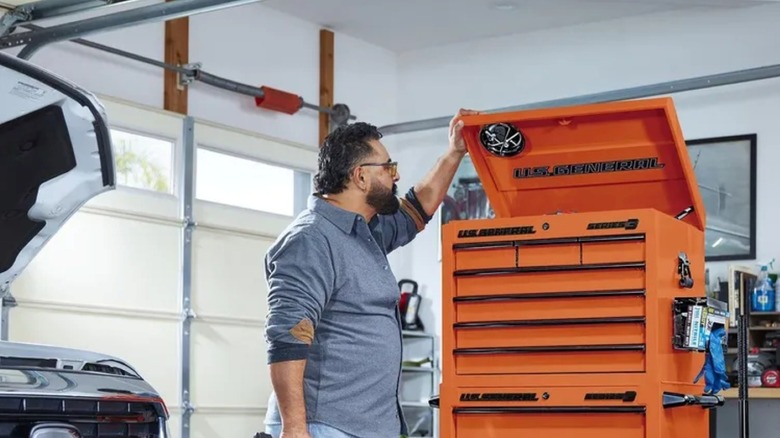 A person in a garage looking inside a U.S. General tool chest.