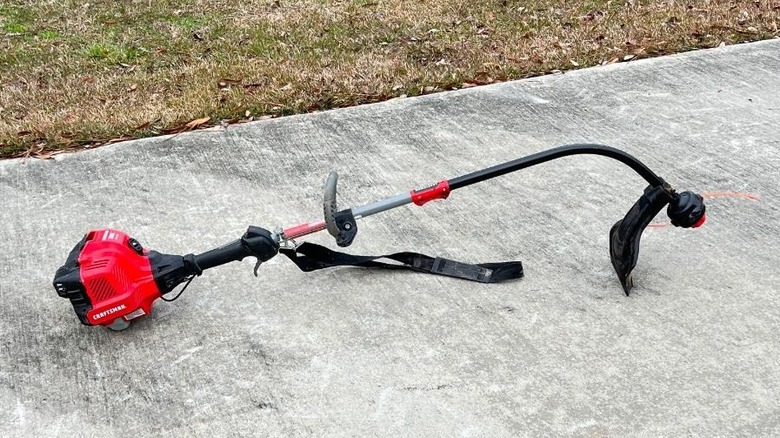 A close up of an Craftsman weed eater on a pavement