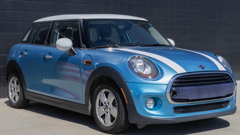 Blue 2024 Mini Cooper with two white stripes parked
