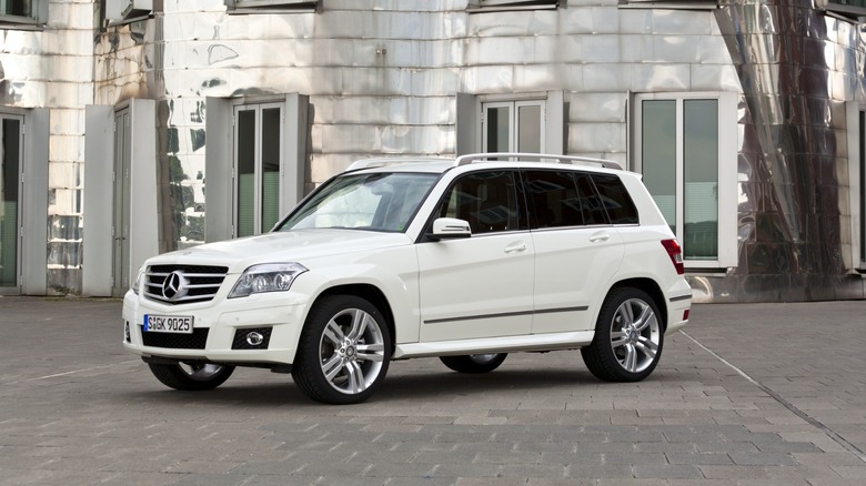 White Mercedes-Benz GLK 2008 model parked in front of a building