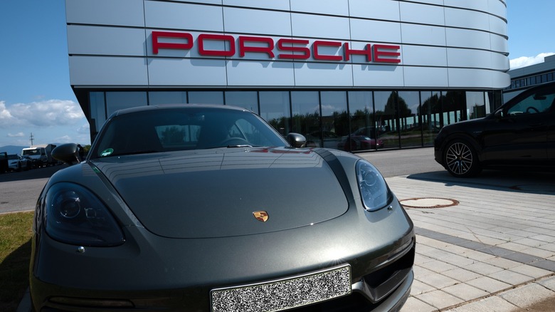 Black Porsche 911 in front of Porsche dealership