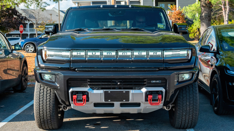 A front-end close-up of a black GMC Hummer pickup truck.