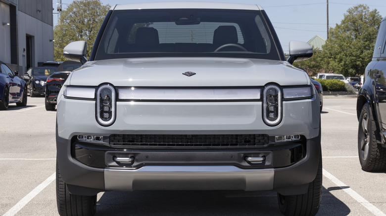 A front-end close-up of a gray Rivian R1T pickup truck.