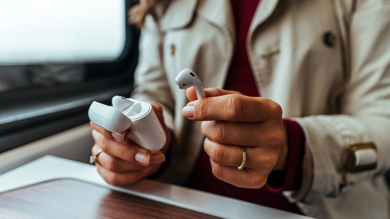 woman holding AirPods in her hand