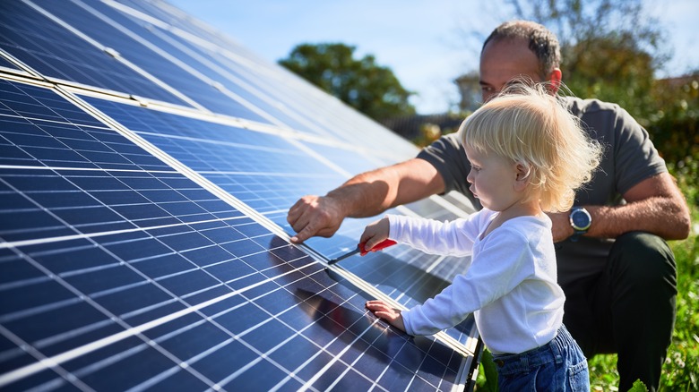Man and child fixing solar panels