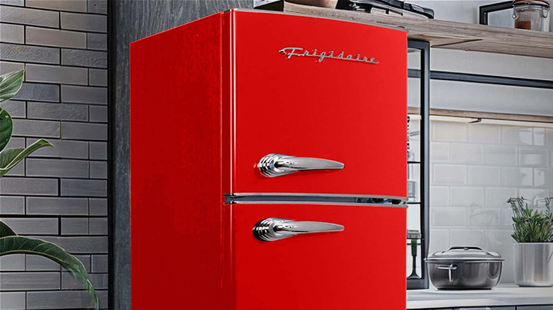 A red retro Frigidaire refrigerator in a kitchen.