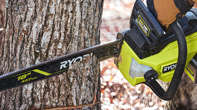 A Ryobi chainsaw chopping down a tree