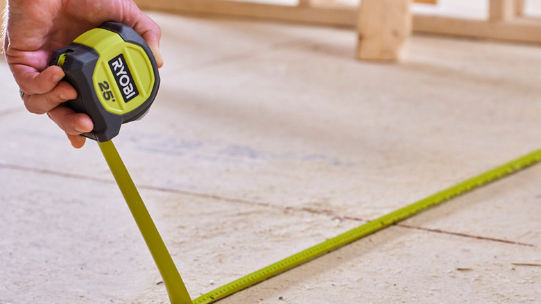 person using ryobi tape measure