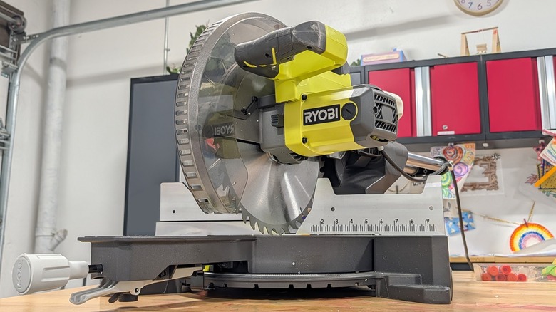 Ryobi miter saw on a wood desk in a workshop.
