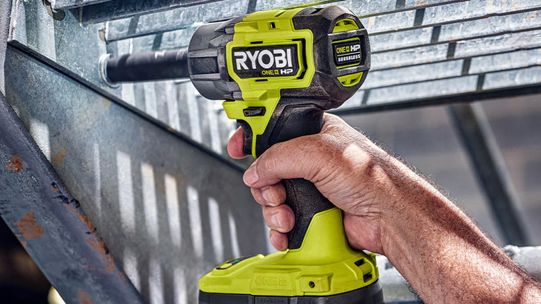 A person using a Ryobi impact wrench to loosen a bolt